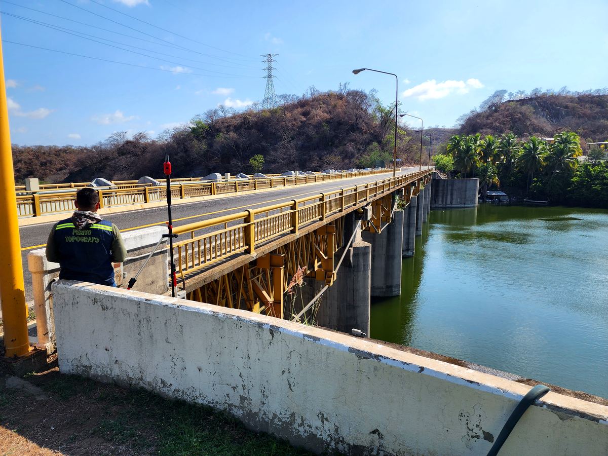 Perito Topógrafo realizando levantamiento en puente sobre presa